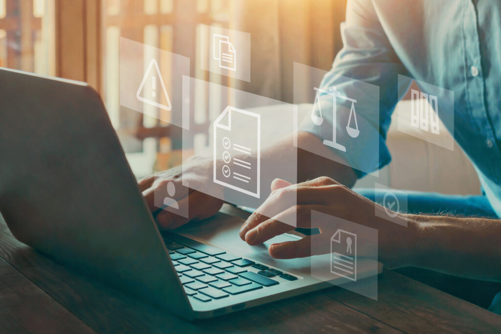 Person typing on a laptop with overlaid icons representing legal compliance, documents, and regulatory checklists.