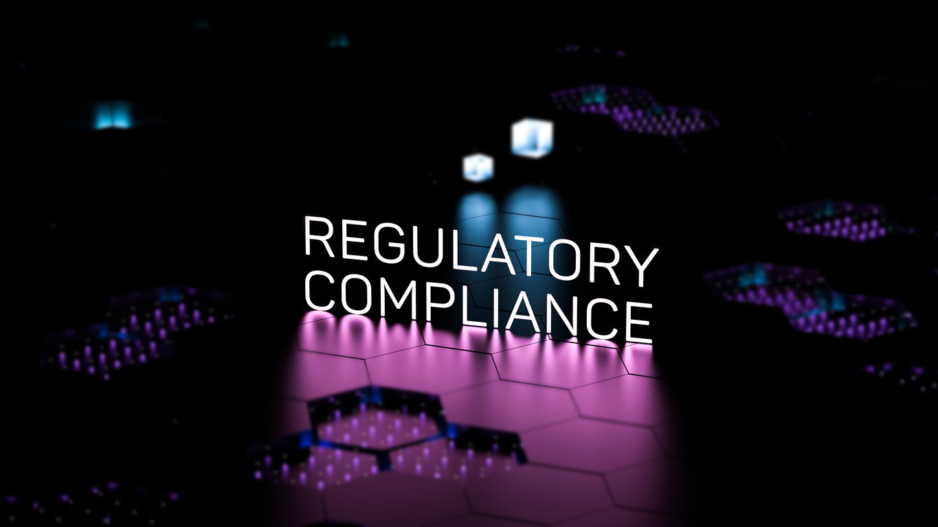 Glowing white "Regulatory Compliance" text on a dark futuristic background with pink hexagonal patterns and blue cube